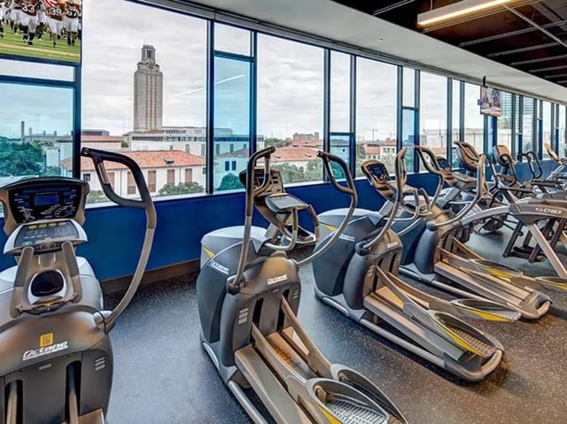 Elliptical machines with city view gym at The Castilian in Austin Student Accommodation