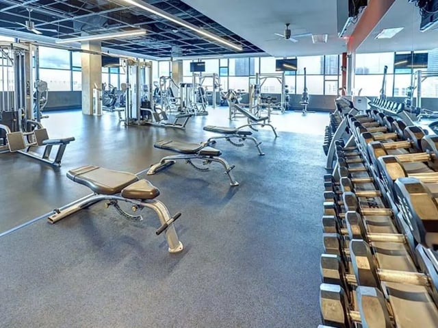 Weight machines benches and dumbbells gym area at The Castilian in Austin Student Accommodation