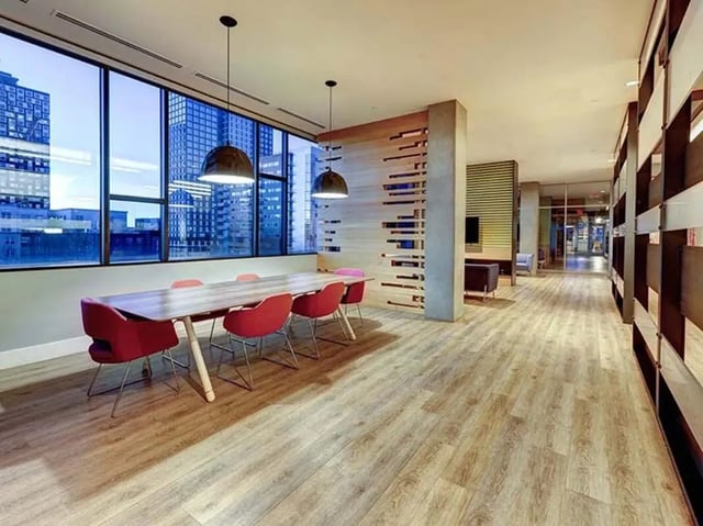 Table with red chairs large windows study area at The Castilian in Austin Student Accommodation