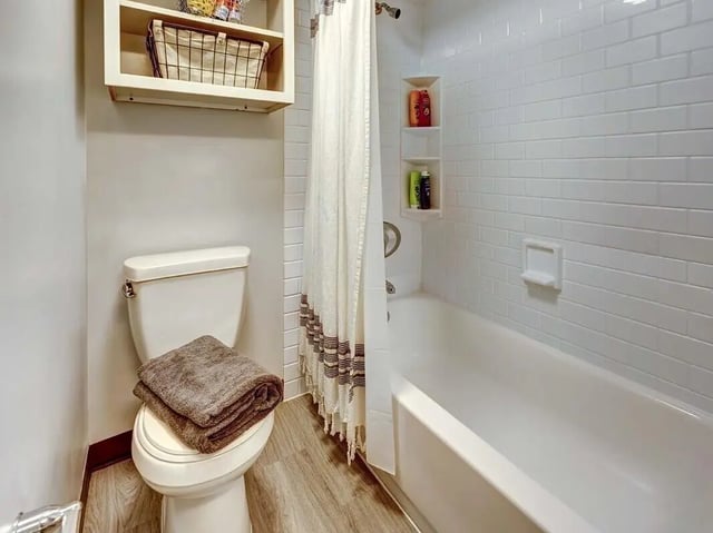 Toilet towels shower curtain bath tub bathroom at The Castilian in Austin Student Accommodation