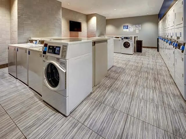 Washing machines and dryers in laundry room at The Castilian in Austin Student Accommodation