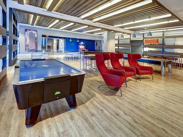 Air hockey table red chairs gaming area recreation room at The Castilian in Austin Student Accommodation