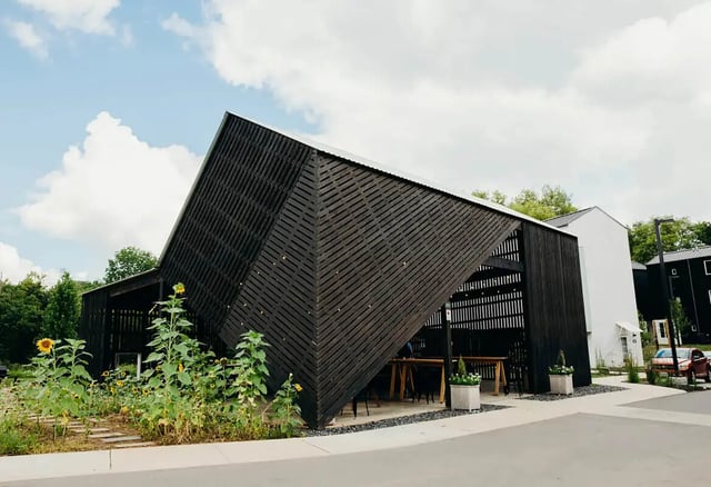 Modern black wood building with sunflowers exterior at Muse Bowling Green in Bowling Green Student Accommodation