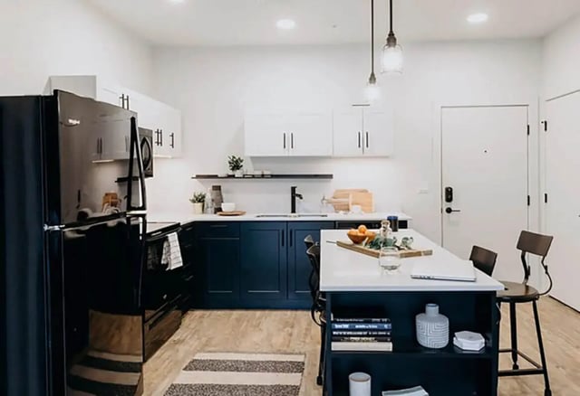Modern kitchen with dark blue cabinets and island kitchen at Muse Bowling Green in Bowling Green Student Accommodation