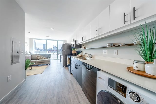 Living room and kitchen with sofa dishwasher and washer kitchen at Muse Omaha in Omaha Student Accommodation