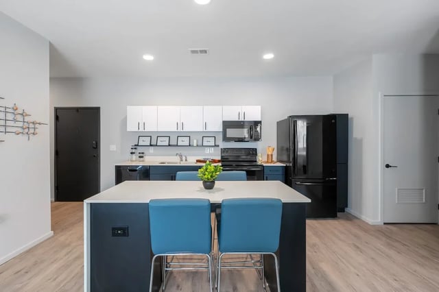 Kitchen island with blue stools appliances kitchen at Muse Omaha in Omaha Student Accommodation
