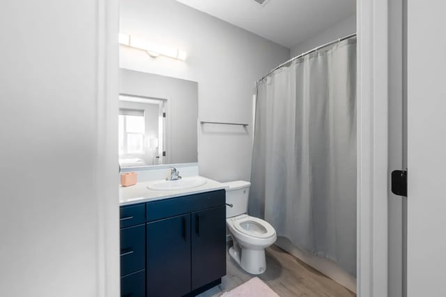 Sink toilet vanity mirror shower curtain bathroom at Muse Omaha in Omaha Student Accommodation