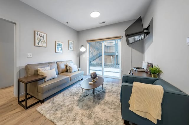 Gray sofa coffee table and tv living room at Muse Omaha in Omaha Student Accommodation