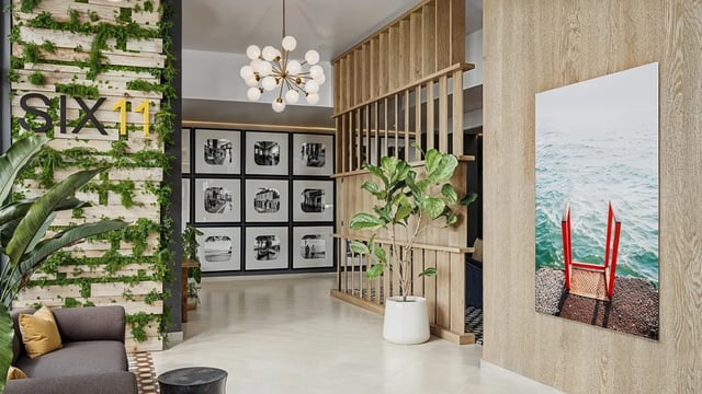 Sofa plant artwork and framed photos communal area at Six11 in Ann Arbor Student Accommodation