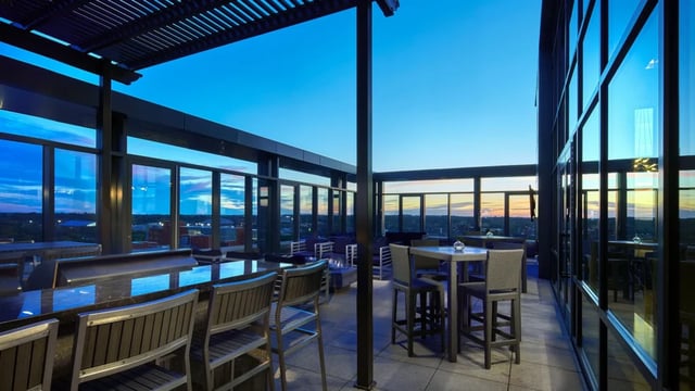 Bar tables chairs and fire pit outdoor lounge area at Six11 in Ann Arbor Student Accommodation
