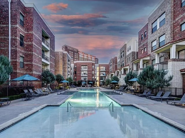 Apartment buildings with pool and lounge chairs exterior at The Village at Overton Park in Lubbock Student Accommodation