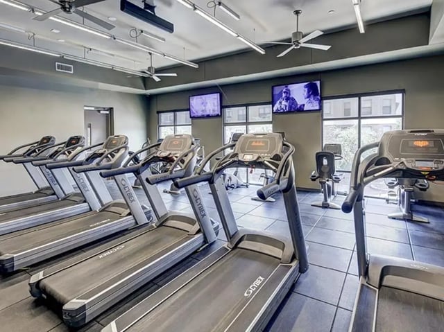 Treadmills exercise bikes televisions gym at The Village at Overton Park in Lubbock Student Accommodation