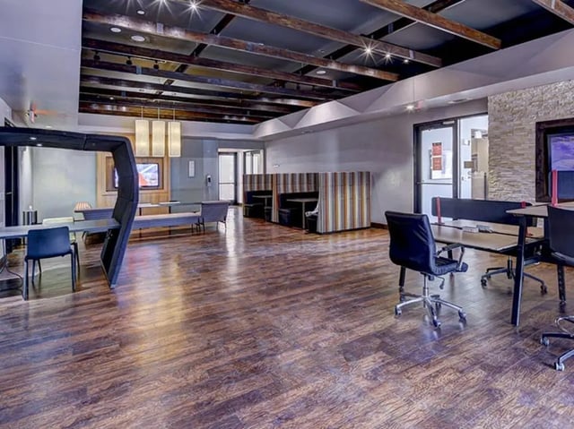 Desks chairs booths and a television common area at The Village at Overton Park in Lubbock Student Accommodation