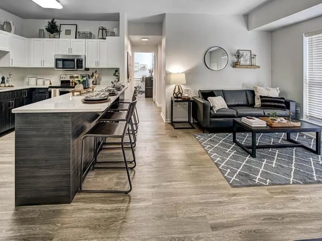 Kitchen island with stools and living room couch living area at University Village at Boulder Creek in Boulder Student Accommodation