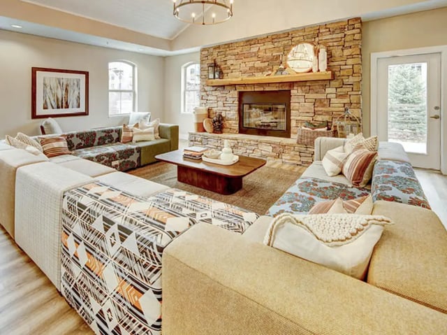 Lounge with sectional sofas stone fireplace living room at University Village at Boulder Creek in Boulder Student Accommodation