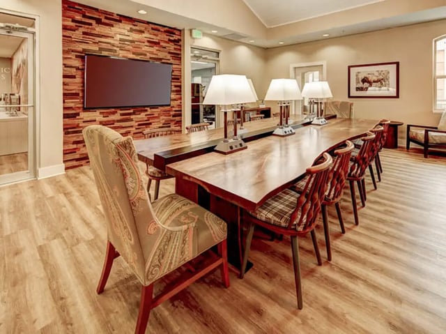 Long wooden table with chairs and lamps communal area at University Village at Boulder Creek in Boulder Student Accommodation