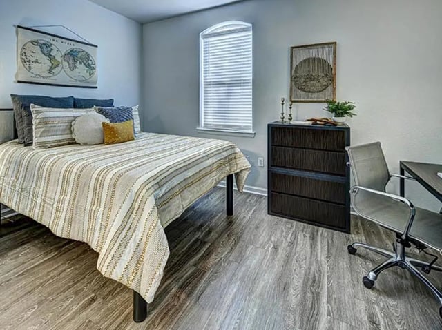 Bed dresser desk chair bedroom interior at University Village at Boulder Creek in Boulder Student Accommodation