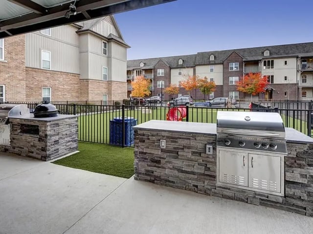 Grills play area fence and buildings exterior at The Lodges of East Lansing in East Lansing Student Accommodation