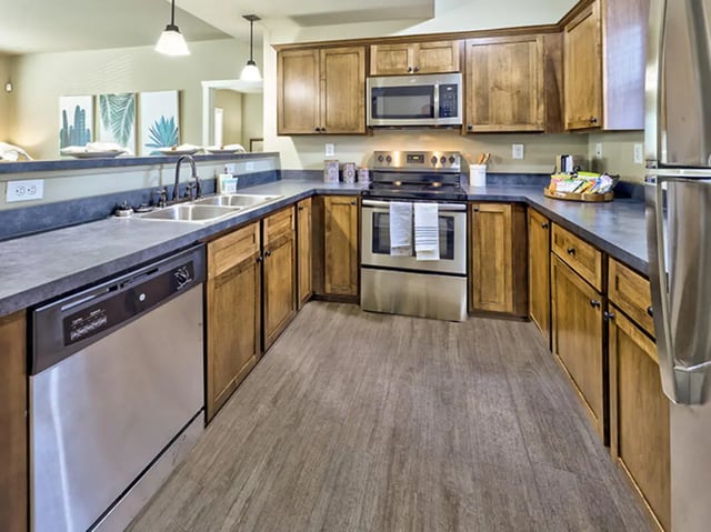 Stainless steel appliances and wooden cabinets kitchen at The Lodges of East Lansing in East Lansing Student Accommodation