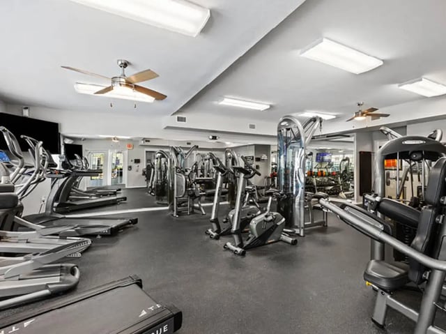 Cardio and weight machines with treadmills gym interior at University Club Apartments in Gainesville Student Accommodation