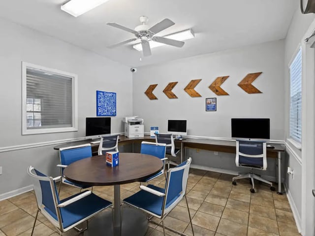 Computers printers and chairs around a table study area at University Club Apartments in Gainesville Student Accommodation