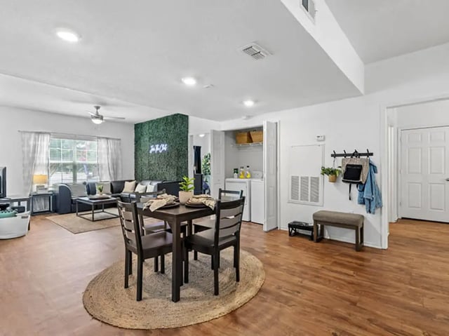 Dining table sofa and laundry area living room at University Club Apartments in Gainesville Student Accommodation