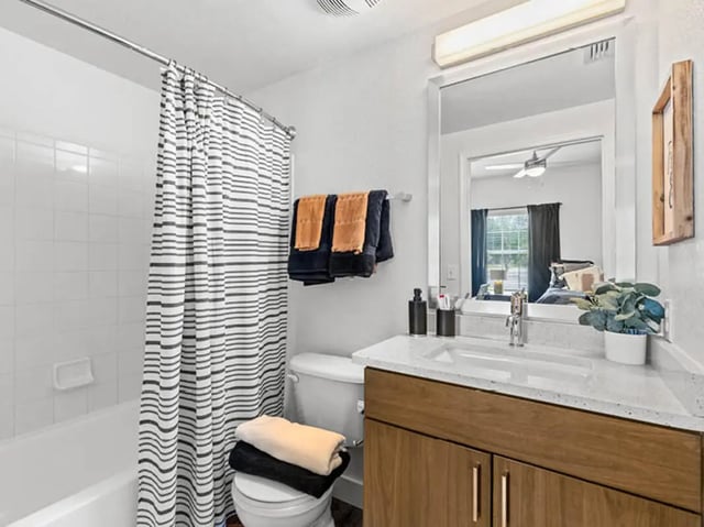 Tub toilet vanity mirror towels bathroom at University Club Apartments in Gainesville Student Accommodation