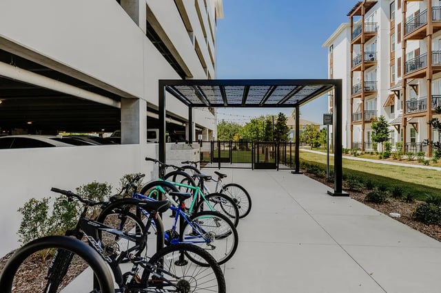 Parked bicycles under a black metal pergola exterior at Current Orlando in Orlando Student Accommodation