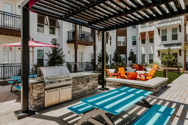 Grill picnic tables orange chairs courtyard exterior at Current Orlando in Orlando Student Accommodation