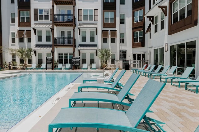 Pool chairs deck apartment building exterior at Current Orlando in Orlando Student Accommodation