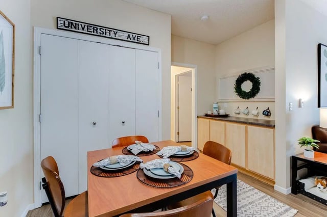 Dining table with place settings and cabinets kitchen area at University Commons in Minneapolis Student Accommodation