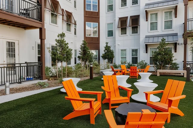 Orange chairs on artificial grass courtyard exterior at Current Orlando in Orlando Student Accommodation