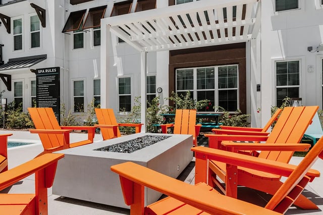 Orange chairs around a fire pit exterior at Current Orlando in Orlando Student Accommodation