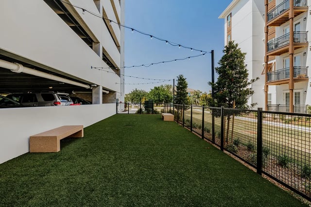 Artificial grass dog park with bench and fence at Current Orlando in Orlando Student Accommodation