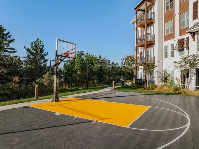 Basketball court next to apartment building playing area at Current Orlando in Orlando Student Accommodation