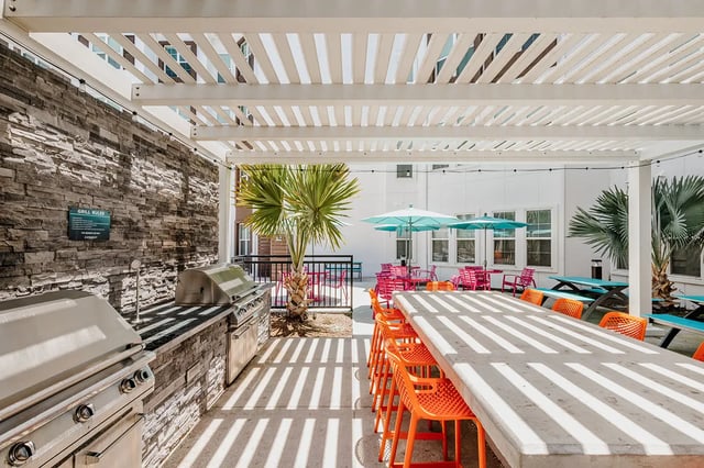 Grill tables umbrellas chairs patio area at Current Orlando in Orlando Student Accommodation