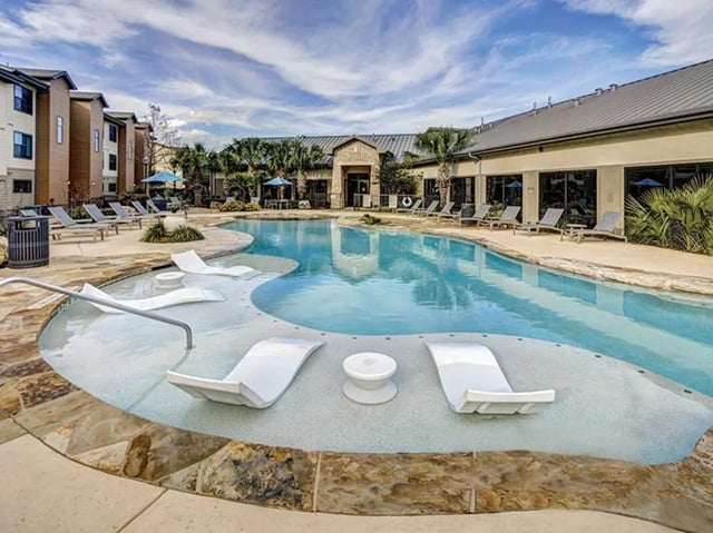 White lounge chairs in swimming pool exterior at Villas at Babcock in San Antonio Student Accommodation