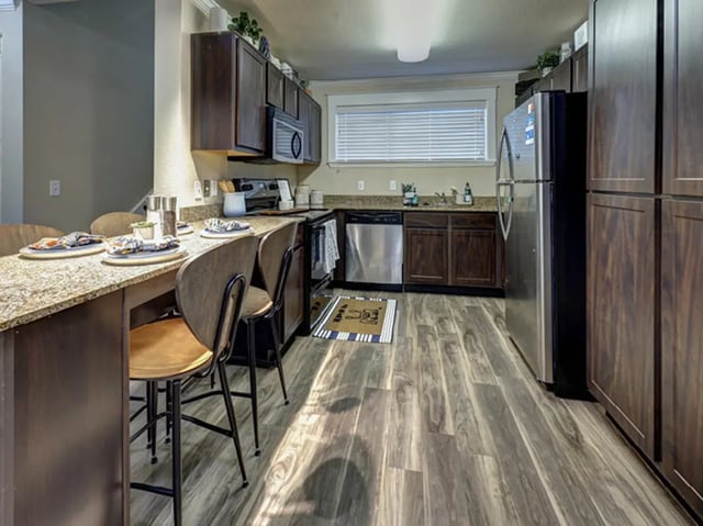 Counter with chairs stainless steel appliances kitchen at Villas at Babcock in San Antonio Student Accommodation