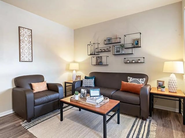 Sofa armchair coffee table and shelves living room at Villas at Chestnut Ridge in Buffalo Student Accommodation