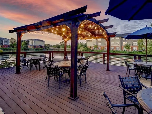 Outdoor patio with tables chairs and string lights exterior at Villas at Chestnut Ridge in Buffalo Student Accommodation