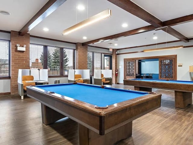 Pool tables with orange seating study areas at Villas at Chestnut Ridge in Buffalo Student Accommodation