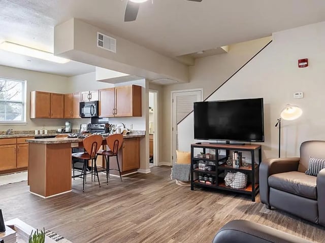 Kitchen island with chairs and living room living area at Villas at Chestnut Ridge in Buffalo Student Accommodation