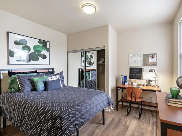 Bed artwork sliding closet desk study area bedroom at Villas at Chestnut Ridge in Buffalo Student Accommodation