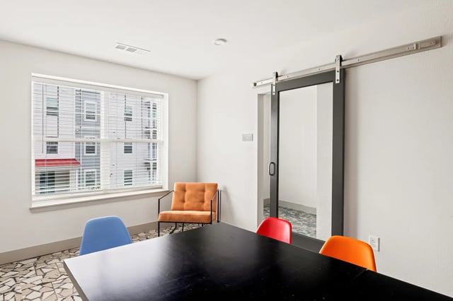 Black table chairs orange chair study area at Atlas Athens in Athens Student Accommodation