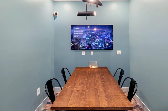 Wooden table with chairs TV security camera study area at Atlas Athens in Athens Student Accommodation