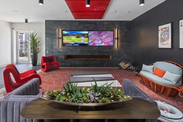 Modern living room with colorful chairs and dual TVs at Atlas Athens in Athens Student Accommodation