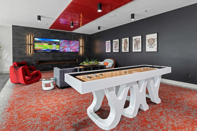 Shuffleboard table lounge chairs televisions artwork playing area at Atlas Athens in Athens Student Accommodation