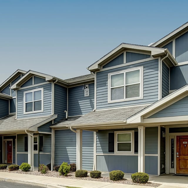 Blue siding townhouses with windows and doors exterior at Villas on Rensch in Buffalo Student Accommodation