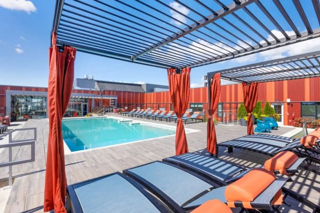 Swimming pool with lounge chairs and pergolas Outdoor area at Atmosphere Madison in Madison Student Accommodation
