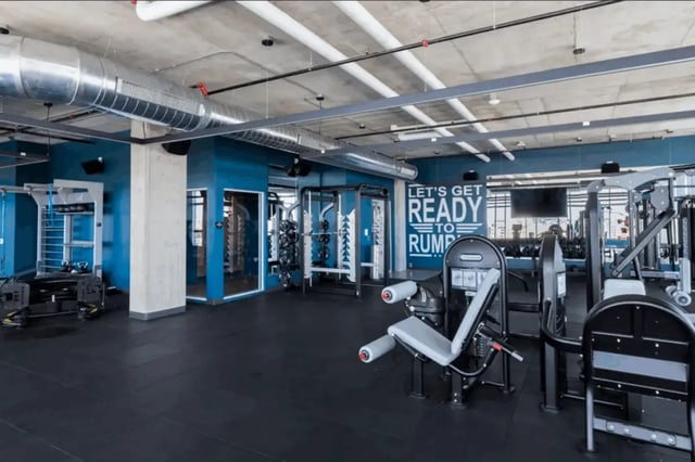Gym equipment with blue walls and a motivational sign fitness center at Atmosphere Madison in Madison Student Accommodation